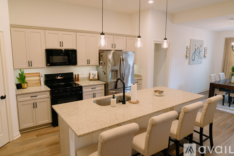 A kitchen with a table and chairs in front of it.