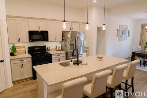 A kitchen with a table and chairs in front of it.