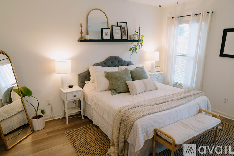 A bedroom with a large bed and a mirror on the wall.