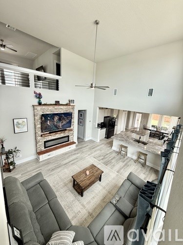 A living room with a grey couch and a fireplace.