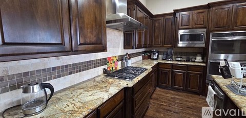 A kitchen with wooden cabinets and a granite countertop.