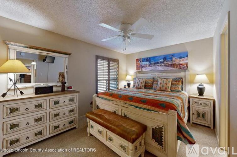 A bedroom with a bed, dresser, and mirror.