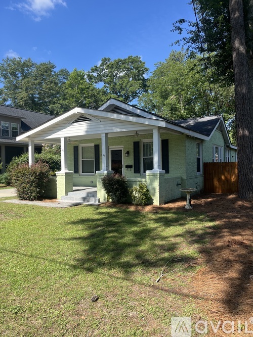 A small house with a porch and a covered entry way.