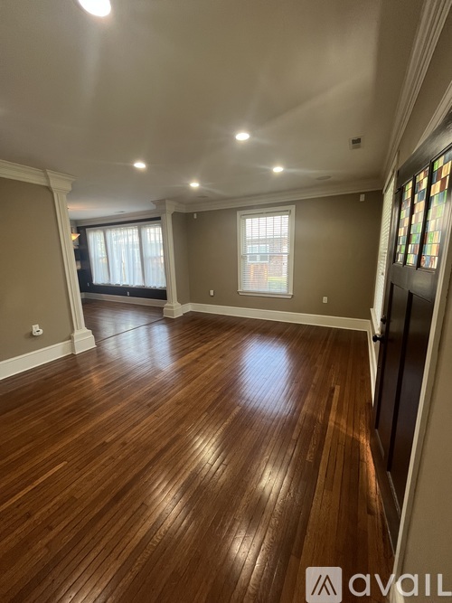 A room with wooden flooring and a stained glass window.