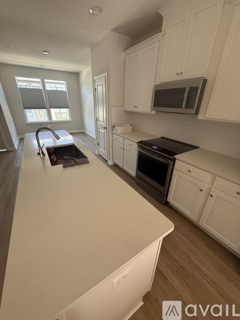 A kitchen with white cabinets and a black countertop.