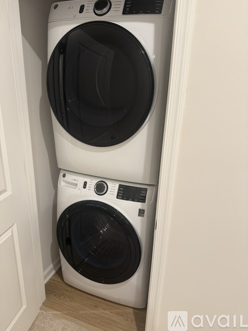 Two white front loading washing machines in a small space.