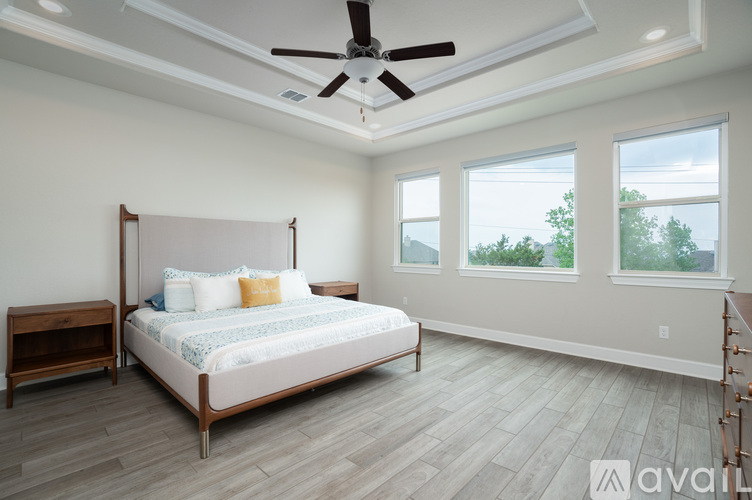 A bedroom with a large bed and a ceiling fan.