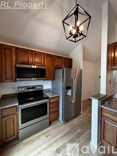 A kitchen with wooden cabinets and stainless steel appliances.