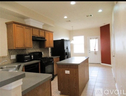 A kitchen with wooden cabinets and black appliances.