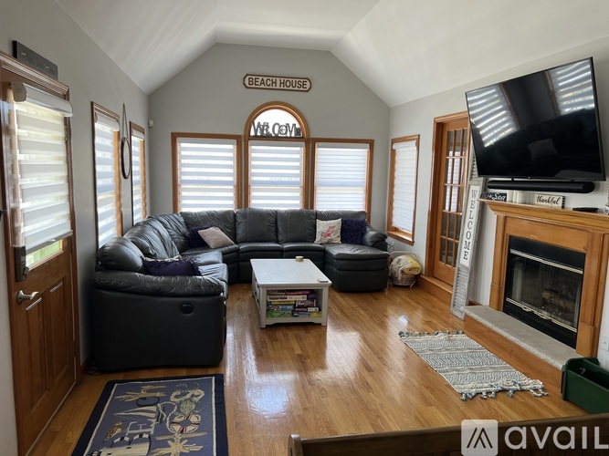A living room with a grey couch and a fireplace.