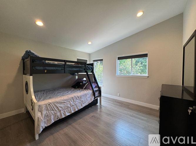 A bedroom with a bunk bed and a dresser.