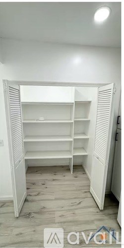 A white closet with shelves and a logo on the bottom right.