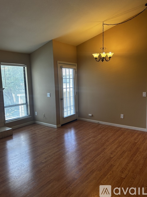A room with wooden floors and a chandelier hanging from the ceiling.