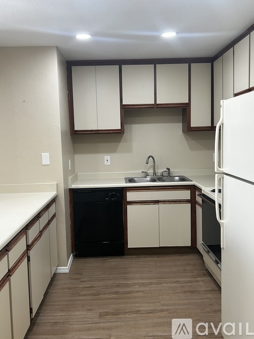 A kitchen with white appliances and wooden cabinets.
