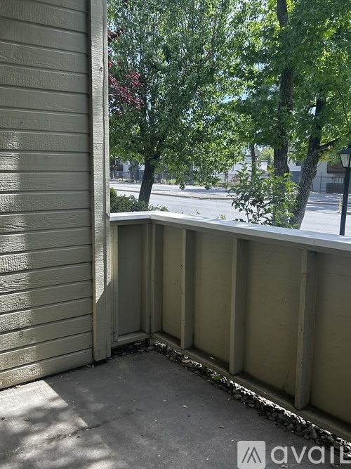 A balcony with a view of a street and trees.
