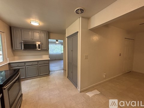 A kitchen with a microwave above the oven and cabinets below it.