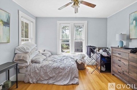 A bedroom with a bed, dresser, and window.