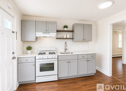 A kitchen with white appliances and grey cabinets.