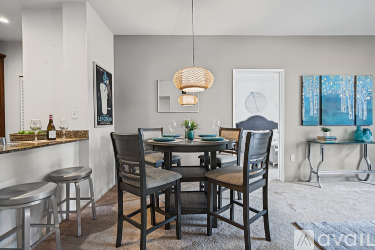 A dining room with a table set for four and a bar area.