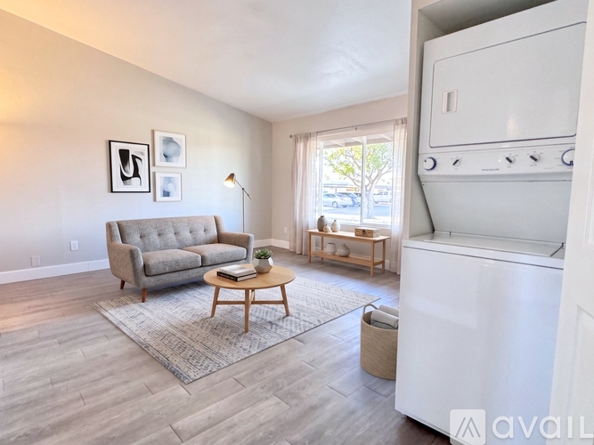 A living room with a grey couch, a coffee table, and a white oven.