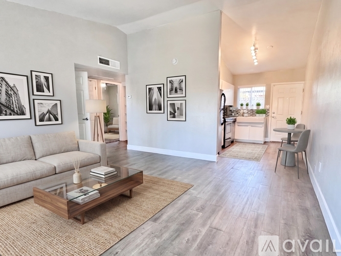 A living room with a couch, coffee table, and pictures on the wall.