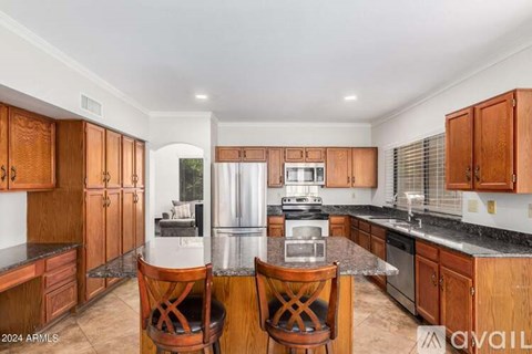 A kitchen with wooden cabinets and a black countertop.