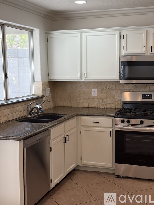 A kitchen with white cabinets and a black stove top oven.