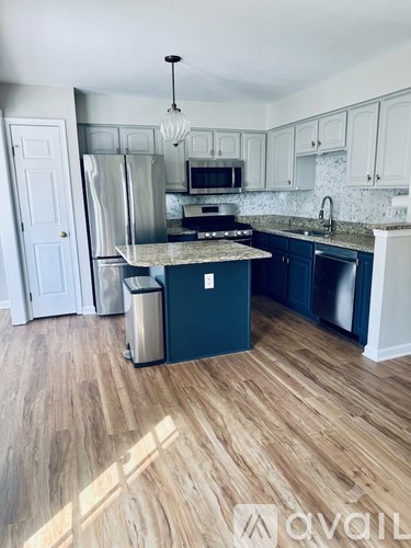 A kitchen with a wooden floor and white walls.