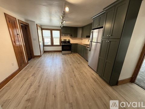 A kitchen with wooden floors and dark cabinets.