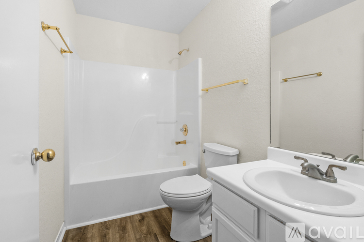 A white bathroom with a toilet, sink, and shower.