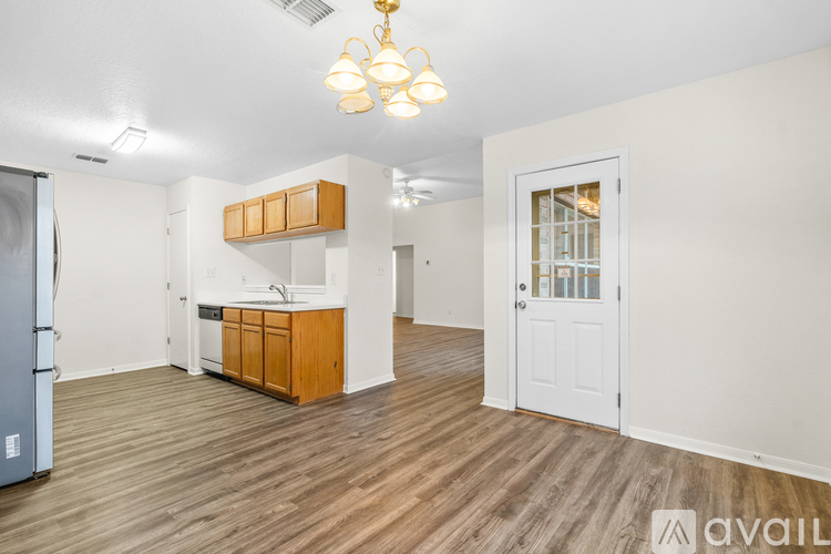 A kitchen area with wooden floors and a white door.