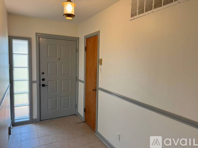 A room with a grey door and a wooden door.