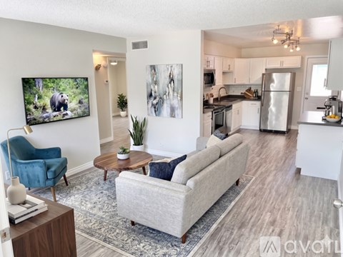 A living room with a blue chair and a grey couch.