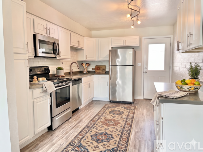 A kitchen with white cabinets and a rug on the floor.