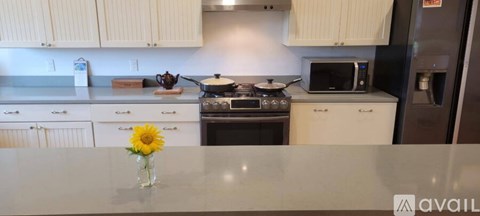 A kitchen with white cabinets and a stove top oven.