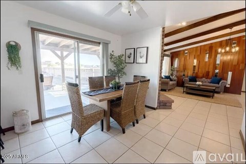 A dining room with a table and chairs.
