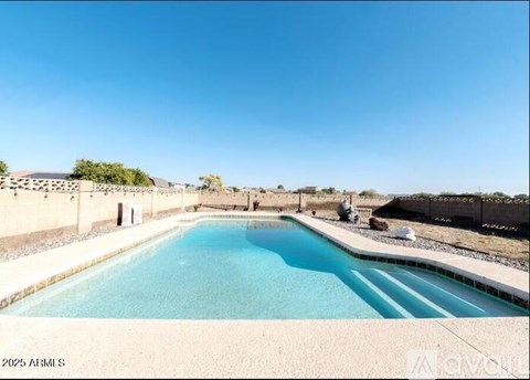 A large outdoor pool surrounded by a concrete wall.