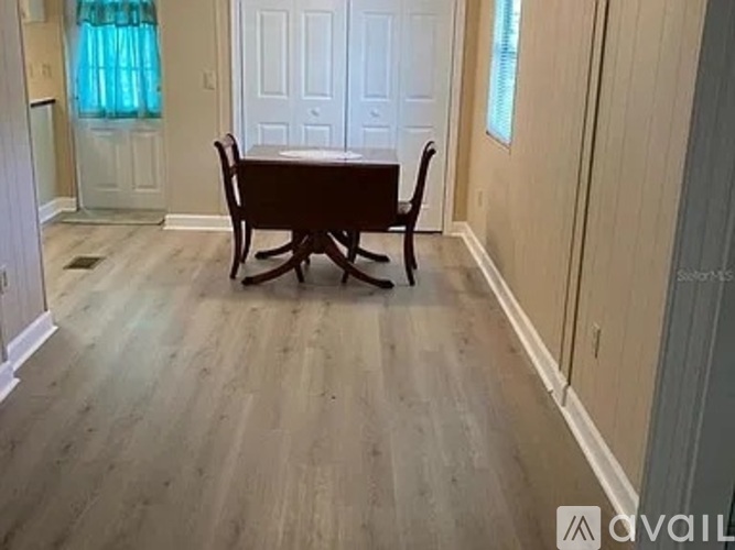 A dining room with a wooden table and chairs.