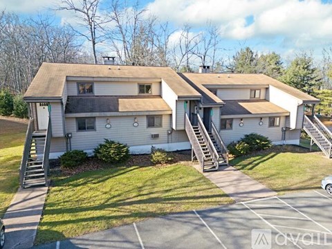 A two-story house with a white exterior and a brown roof.