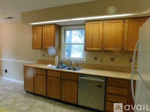 A kitchen with wooden cabinets and a white fridge.