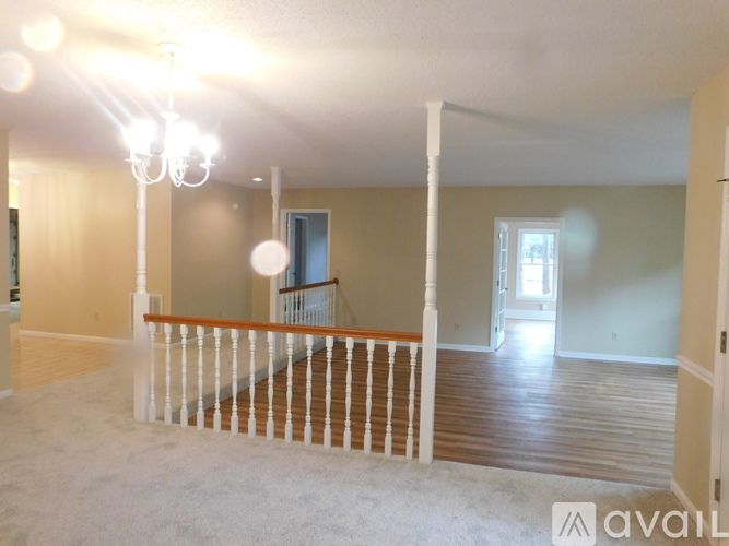 A living room with a staircase and a chandelier.