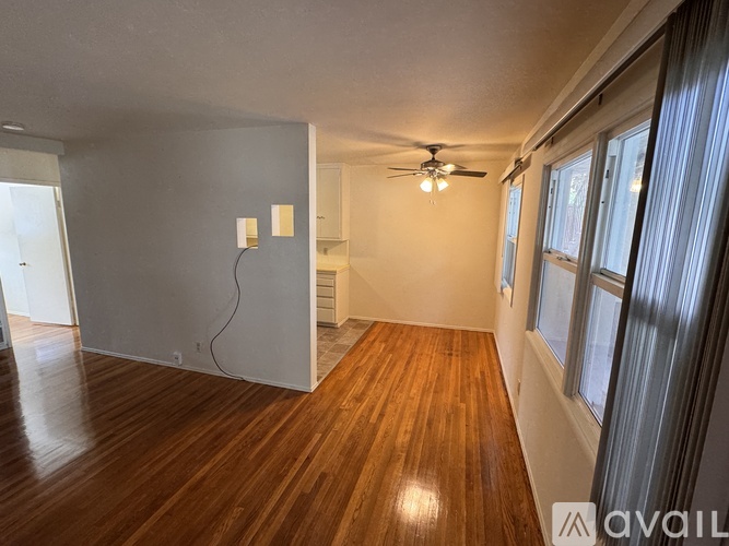 A room with wooden floors and a ceiling fan.
