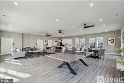 A spacious living room with a central coffee table and a large window on the right side.