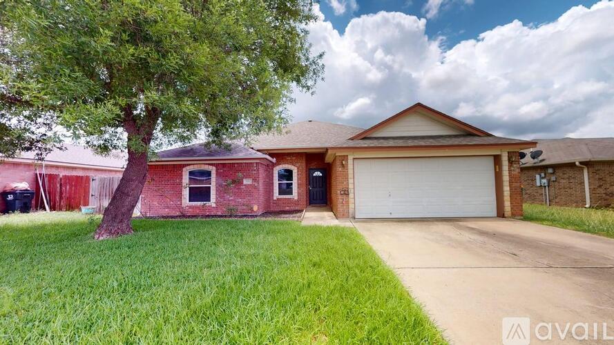 A house with a red brick exterior and a white garage door is for sale.