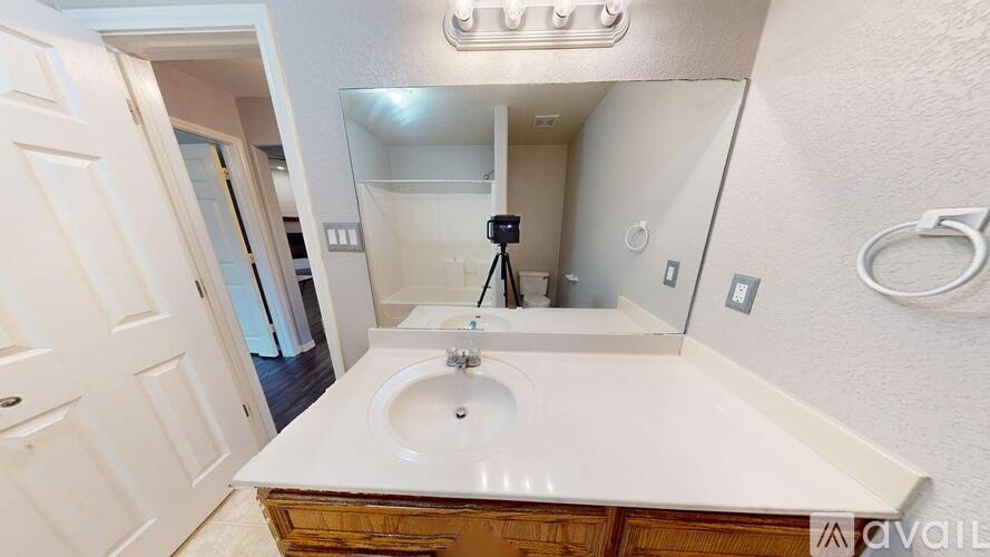 A bathroom with a sink, mirror, and a door.