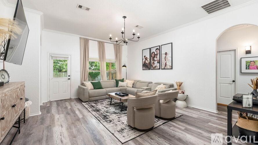 A living room with a grey sofa set and a chandelier.