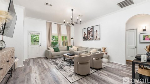 A living room with a grey sofa set and a chandelier.
