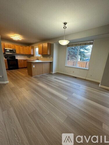 A spacious kitchen with wooden cabinets and a black oven.