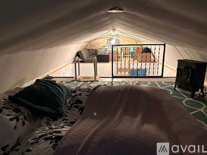 A bedroom with a bed, a chair, and a nightstand.