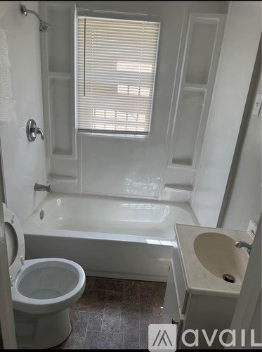 A white toilet is next to a bathtub in a bathroom.